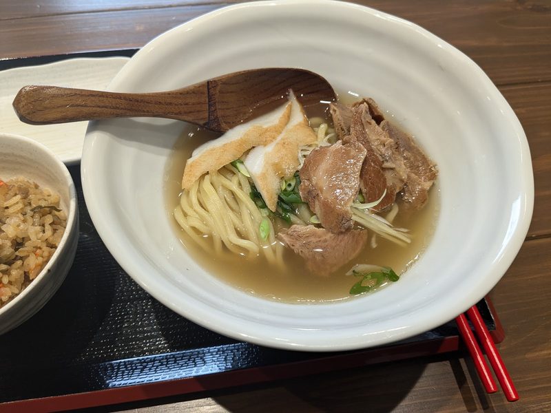 かまぼこと豚肉をのせ、木のれんげを添えた澄んだスープの宮古そば