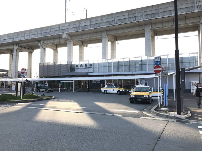 青空の下の羽犬塚駅の駅舎と駅前